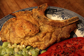 Thin cut pork chops, dredged in a well seasoned blend of onion enhanced flour and cornmeal and pan fried in a cast iron skillet. Pictured here with succotash and fresh sliced Creole tomatoes.