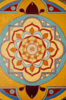 Photograph of a mandala in orange, red, yellow, cyan and blue.