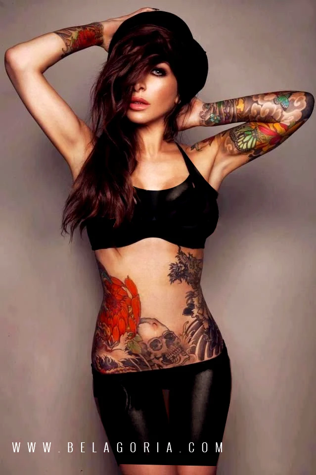 Espectacular mujer morena tatuada, destaca en su abdomen un tatuaje de calavera japonesa