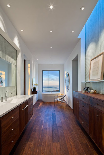 Bathroom in Home with Wooden Vanity and White Sink near the White Tub