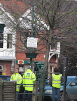 Electrical contractors pause as they string bulbs along the Square's trees