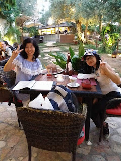 Audre Teo and friend in a lovely garden restaurant in Spain