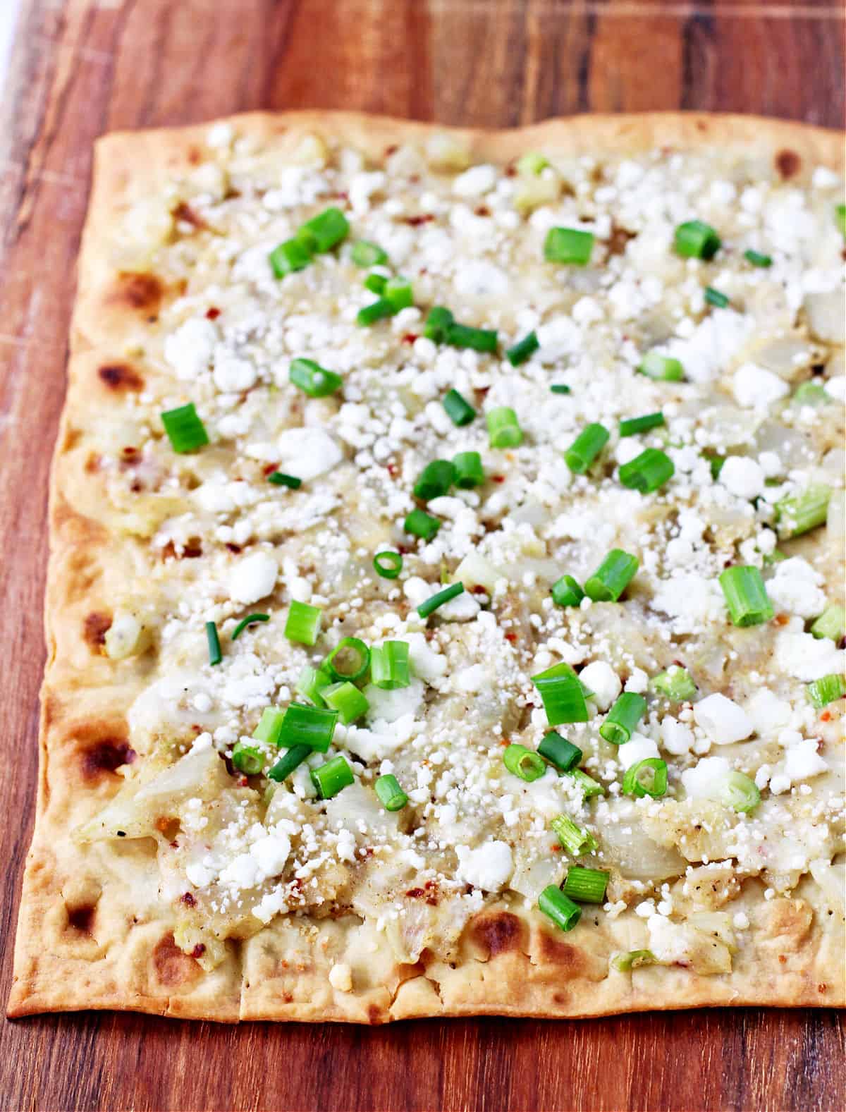 Lavash Pizza with Cauliflower, Fennel, and Mozzarella whole on a cutting board.