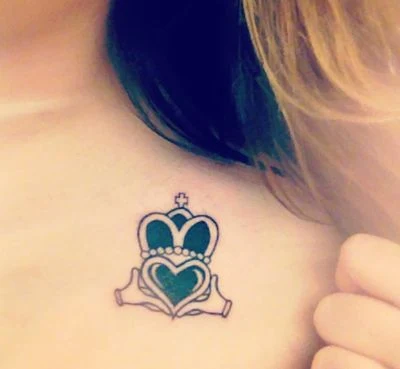 chica con tatuaje celta del claddagh en el pecho