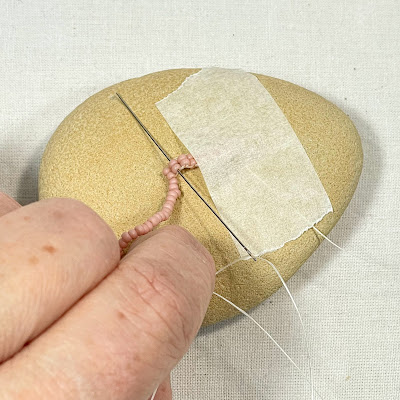 Stitching through ladder stitch to secure twisted fringe