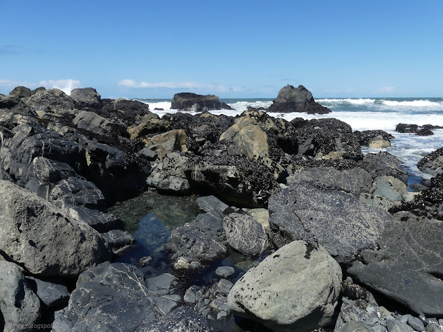 29: shallow water surrounded by big rocks above the waves