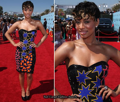 Singer Keri Hilson in a black bustier dress with Casadei black satin pumps