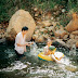 The image of a husband and wife playing together by the stream.