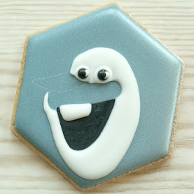 Blue cookie with Olaf's mouth, eyes, teeth and face piped, photo by Honeycat Cookies