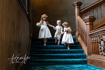 Flower girls and page boy walking down the stairs at Matfen Hall