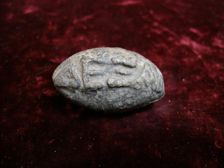 a stone, with greek "CATCH" embedded.