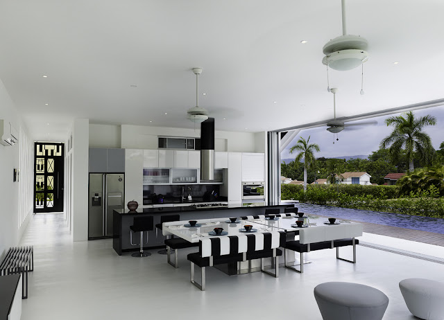 Modern black and white kitchen and dining room by the swimming pool 