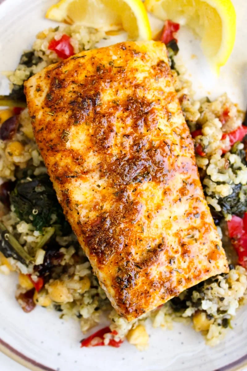 Cajun Baked Mahi Mahi on a bed of quinoa on a cream colored plate.