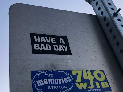 Sticker on back of street sign saying, "Have a Bad Day"