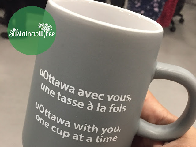 A reusable uOttawa coffee mug with a slogan on it