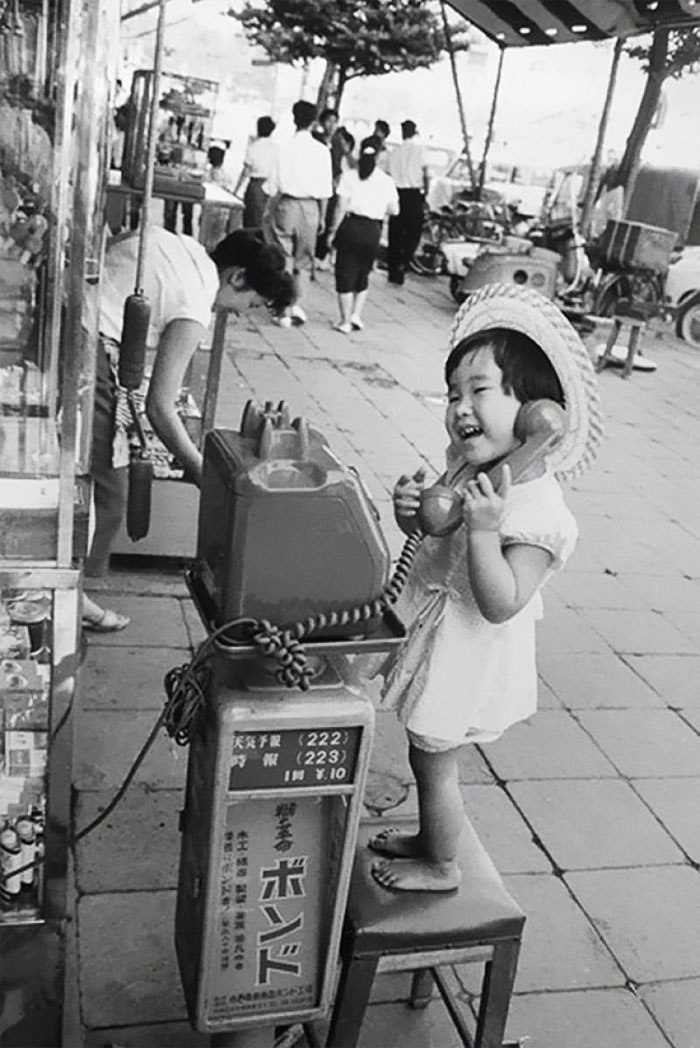 60 Inspiring Historic Pictures That Will Make You Laugh And Cry - A Little Girl Having Fun Pretending To Talk On The Telephone, Japan, 1958