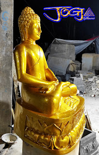 Patung budha di buat dari batu putih (batu jogja) yang diberi pewarna cat emas (gold)