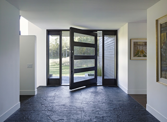 Picture of large black entrance doors as seen from the hallway inside