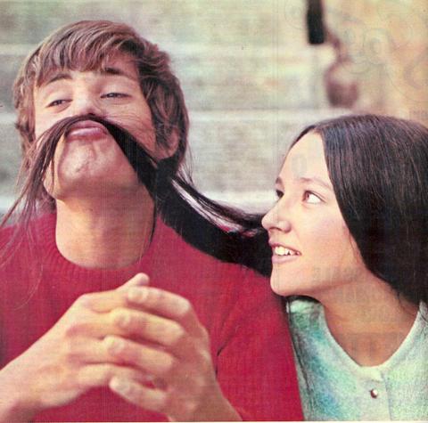 Leonard Whiting and Olivia Hussey making a mustache from Hussey's locks