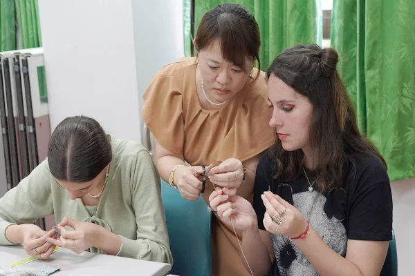 ▲大葉大學藥保系張淑微老師(中)教導境外學生製作香包。（大葉大學提供）