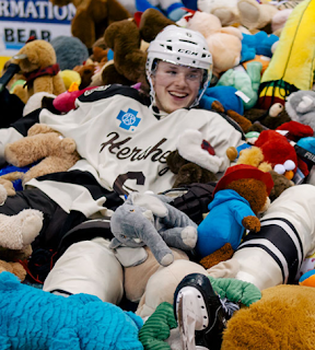 Johansen and a teammate lost in a sea of teddy bears during Teddy Bear Toss Night in Hershey
