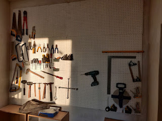 A peg board with tools on it