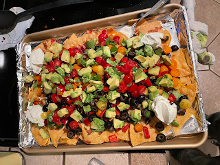 Nachos with veggies and sour cream.