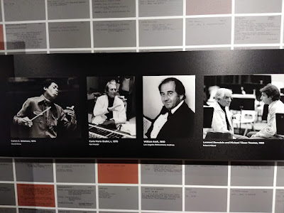 A display showing conductors associated with the LA Philharmonic - LtoR: Calvin Simmons, Carlo Maria Giulini, William Kraft, Leonard Bernstein with Michael Tilson Thomas (n.d.)