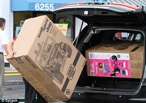 Tight fit: A Toys R Us sales adviser tries to fit the two baby jeeps into 