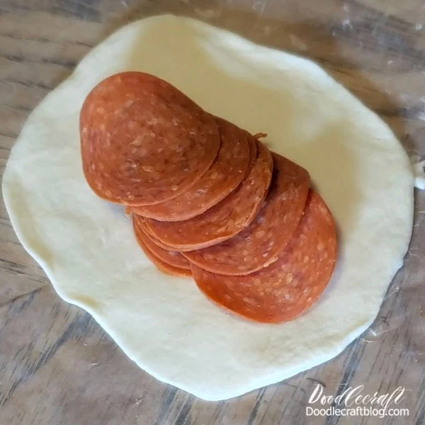 Place a layer of pepperoni slices evenly across the rolled-out dough.