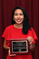 Dr. Nguyen-Tran smiles and holds her award plaque 