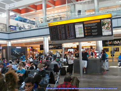 Área de espera y paneles informativos en el aeropuerto de Heathrow