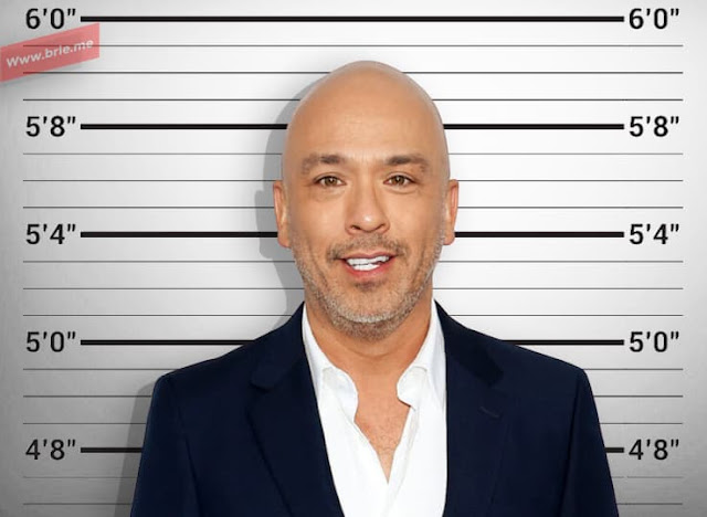 Jo Koy standing in front of a height chart