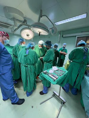 A view of the operating room with a full surgical team working on a patient,