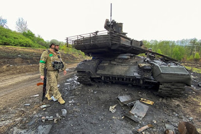 Soldado ucraniano caminha ao lado de um tanque de guerra russo destruído T-90M Proryv, enquanto o ataque da Rússia à Ucrânia continua, perto da vila de Staryi Saltiv na região de Kharkiv, Ucrânia, em 9 de maio de 2022. REUTERS/Vitalii Hnidyi (Stringer/Reuters)