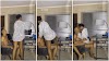 A young lady pauses her man from working, sits on his lap, and starts kissing and romancing him