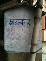 Image of post outside a house with the word 'Sarkar' illustrated in Bengali
