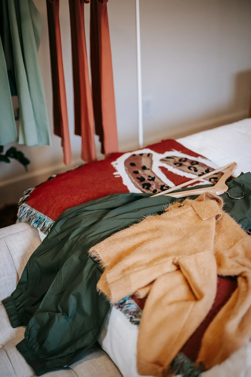 messy pile of clothes on a bed