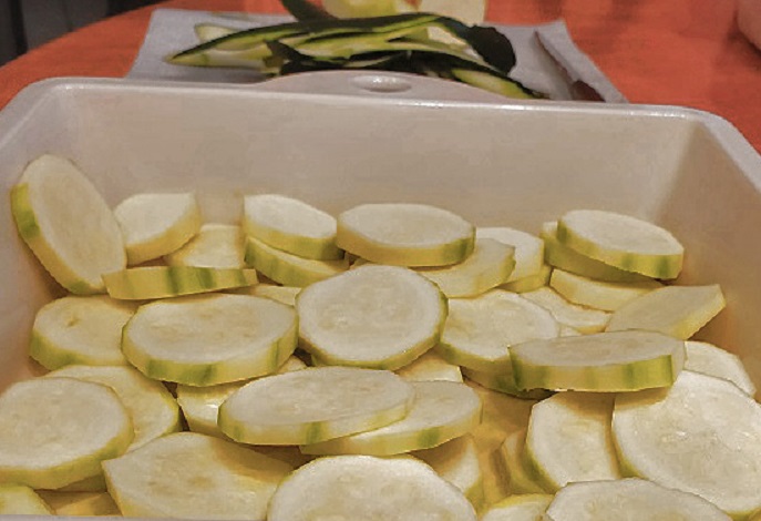 this is sliced zucchini and yellow squash in a casserole dish