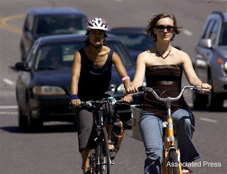 Bicyclists travel with traffic down Broadway Street in Portland, Ore.