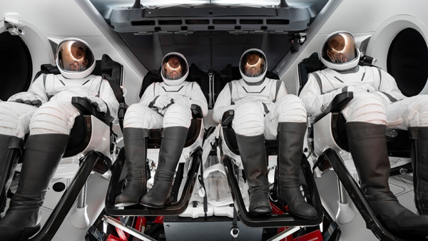 Donning SpaceX's new EVA suit, the Polaris Dawn crew takes a group photo inside a Crew Dragon capsule.