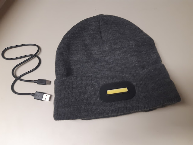 Gorro con linterna y altavoces bluetooth. junto con el cable de carga