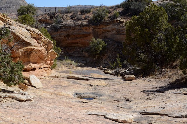 canyon with a hole in the rock in the middle that has water