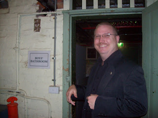 Kyle in the basement standing by the old boys' bathroom