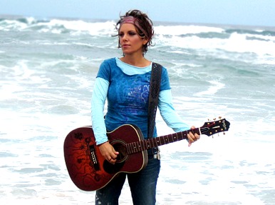 Foto de Soraya con su guitarra en la playa