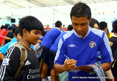 Ruzaini Zainal (right) signs on a poster of a fan