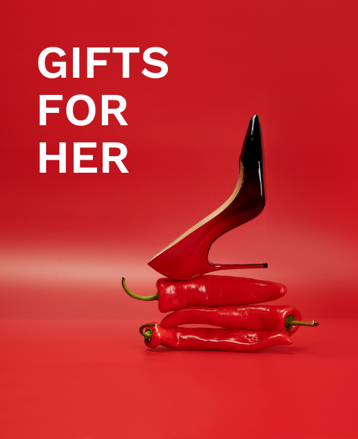 Photo of Christian Louboutin red and black ombre high heel resting sideways atop 3 chilli peppers on a red backdrop. Text on screen reads Gifts for her