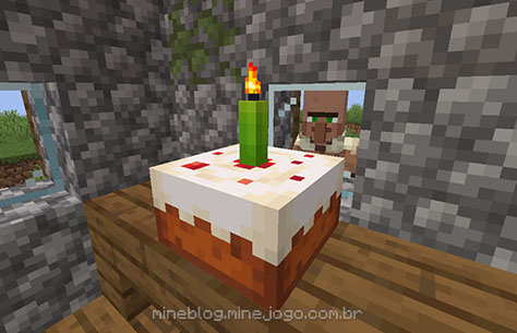 Bolo com uma vela verde acesa enquanto um aldeão observa
