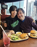 Teen with Dad in a restaurant in front of two juicy burgers