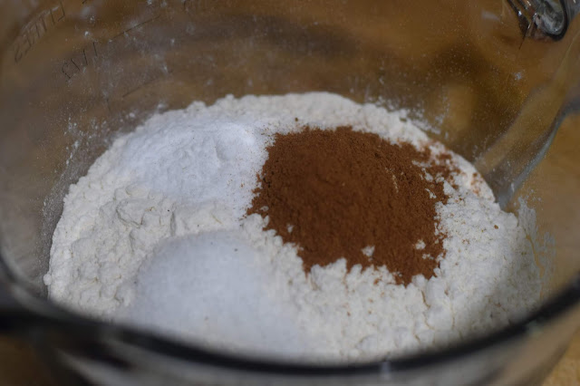 The flour, salt, baking soda, and pumpkin pie spice combined in a mixing bowl. 